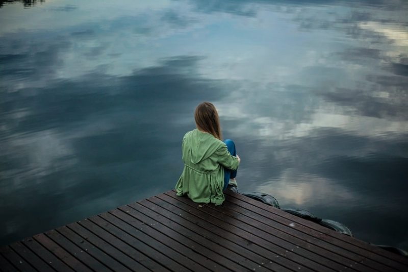 Mujer sentada en lago Mujer sentada en lago