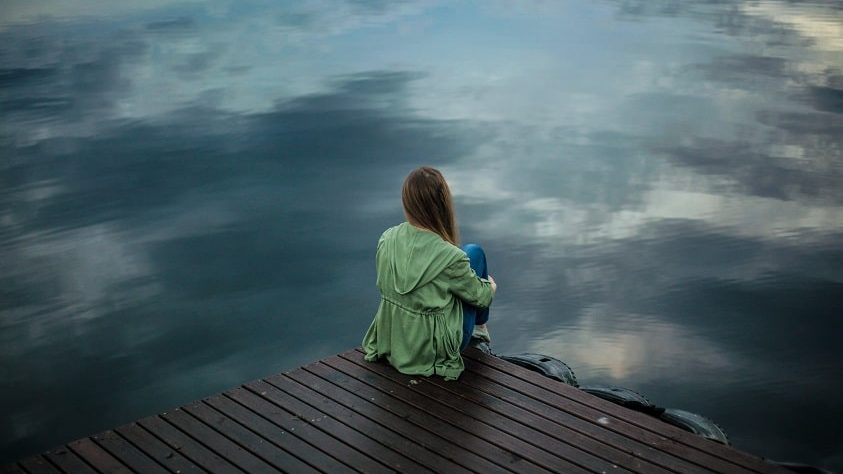 Mujer sentada en lago